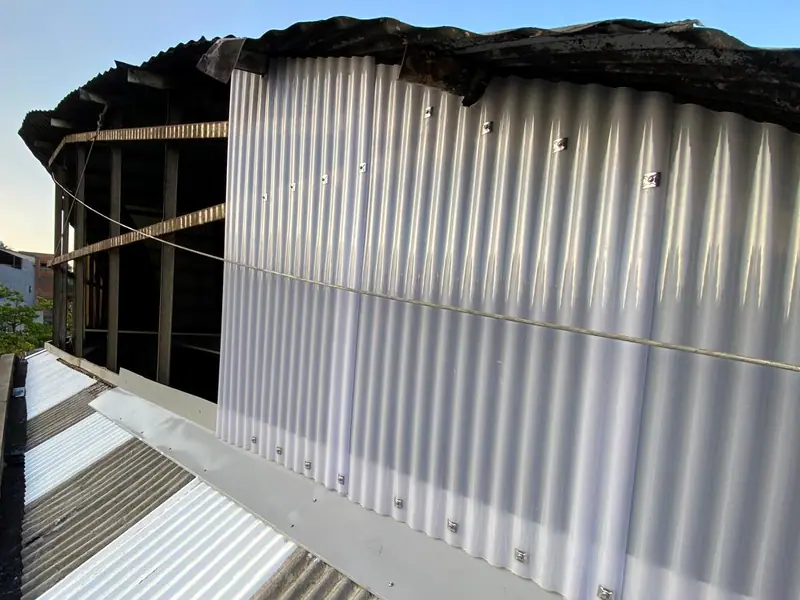 As telhas novas sendo colocadas no fechamento durante a obra